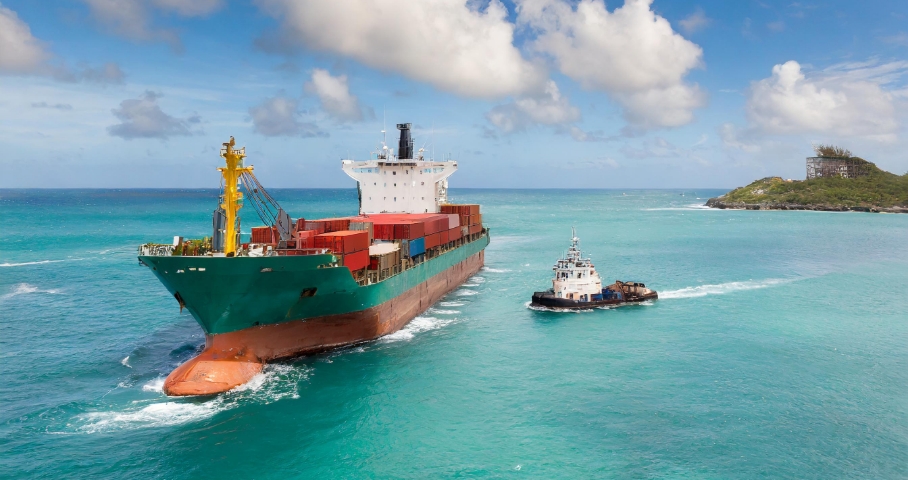 Image of a feeder ship approaching a container ship above the sea